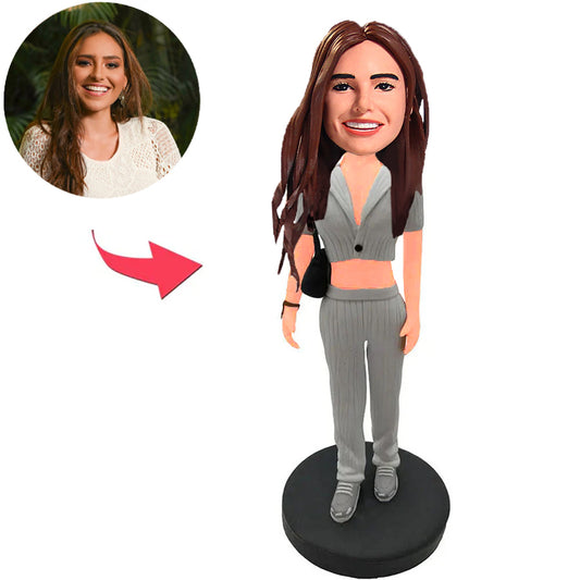 Glückliches Mädchen im grauen Anzug mit Tasche Kundenspezifische Bobbleheads mit graviertem Text