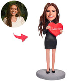 Die Frau, die eine Liebes-Herz-kundenspezifische Bobblehead hält, addieren Text